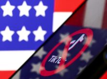 In this photo illustration, logo of Tiktok is displayed on mobile phone screen in front of flag of United States.