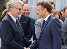 French President Emmanuel Macron (R) shakes hands with EU commissioner for internal market Thierry Breton as he visits the International Paris Air Show at the ParisLe Bourget Airport on June 19, 2023.